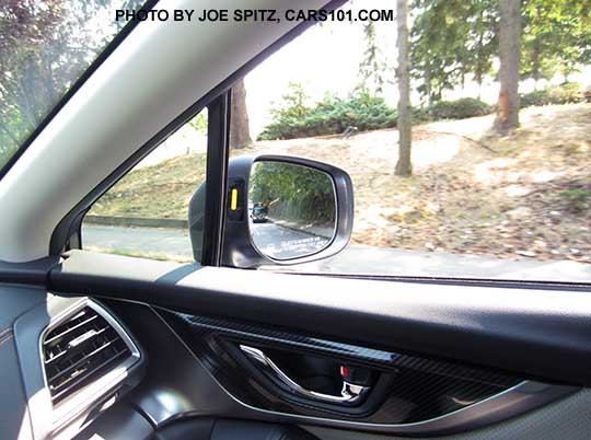 2018 Subaru Crosstrek's yellow blind spot detection symbol displays in the outside mirror housing, passenger side shown.