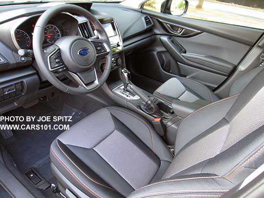 2018 Subaru Crosstrek Premium, silver shift plate,  leather wrapped steering wheel and black cloth with orange stitching shown.
