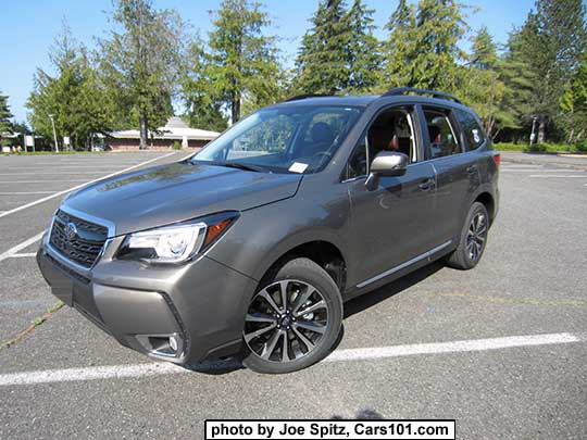 2017 Forester 2.0XT Touring with dark tinted rear glass, chrome rocker panel strip and fog lights trim. Sepia Bronze Metallic color shown. XT model has redesigned for 2017 blacked-out front grill with gloss black center strip and center logo, and 18" black and silver 5 split-spoke alloy wheels