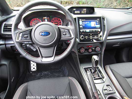 2017 Subaru Impreza Sport steering wheel, red lit dash gauges, 8" audio screen, gloss black CVT shift knob and surround, manual heat/ac knobs, and black sport cloth interior with red stitching