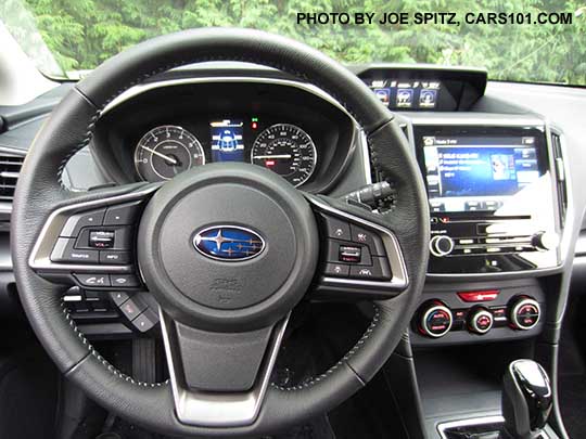 2017 Subaru Limited leather wrapped steering wheel, silver stitching. Notice the Limited's off-white dash gauges, silver trimmed automatic climate control in the background
